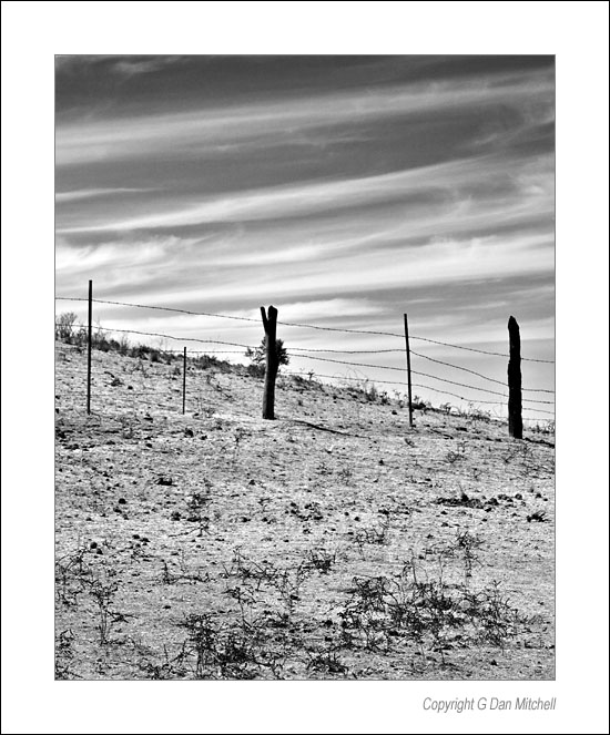 CaleroWireFence2006|08: Barbed Wire Fence, Clouds. Calero Hills, California. August 23, 2006. &copy; "Copyright G Dan Mitchell".    keywords: barbed wire fence clouds horse pasture calero hills california black and white photograph
