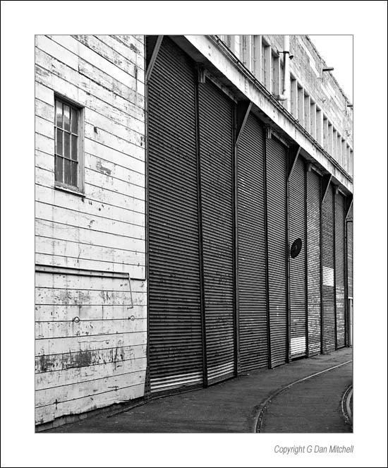 GreenDoorsEmbarcaderoBW2006|08|25: Metal Doors, The Embarcadero. San Francisco, California. August 25, 2006. &copy; "copyright g dan mitchell".    keywords: metal doors the embarcadero wooden building san francisco california black and white photograph
