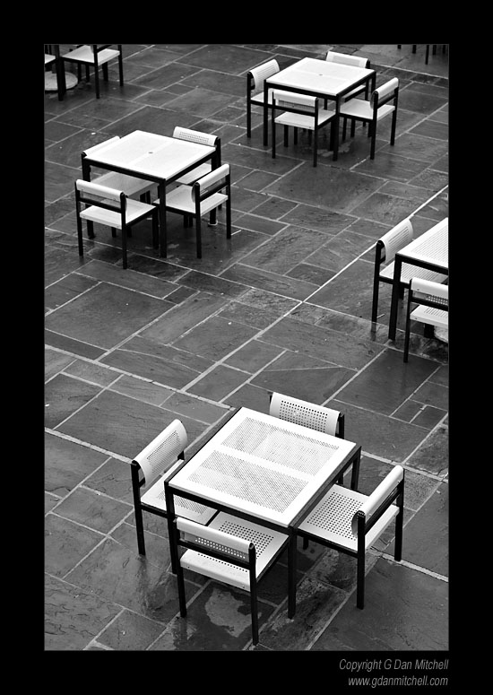 UCLATablesPatio2007|01|27: Patio and Tables. University of California, Los Angeles. January 27, 2007. &copy; "Copyright G Dan Mitchell". ("sales")    keywords: white tables chairs patio rain wet stone floor ucla university of california los angeles black and white photograph