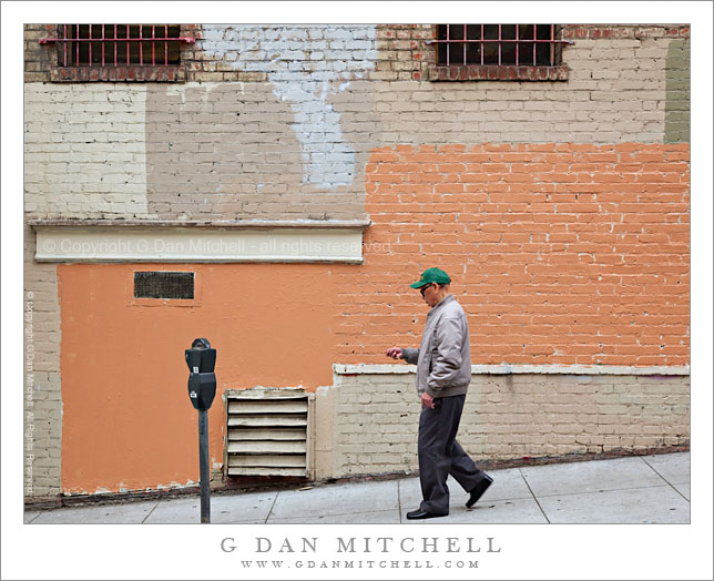 Man Walking Past Painted Brick Wall