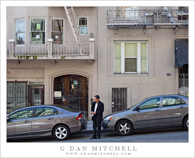 Man in Suit Between Two Cars Man in Suit Between Two Cars